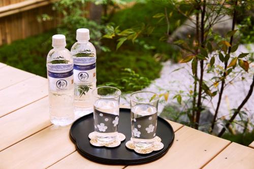 2 bouteilles d'eau et 2 verres sur une table dans l'établissement Rinn Fushimiinari, à Kyoto