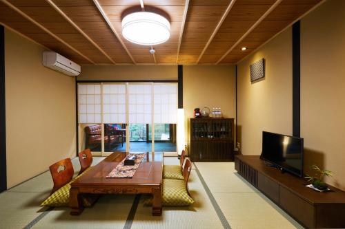 a living room with a table and chairs and a television at Rinn Fushimiinari in Kyoto