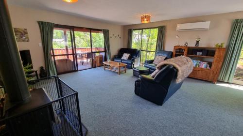 a living room with two chairs and a couch at 27 Alpine Avenue in Hanmer Springs