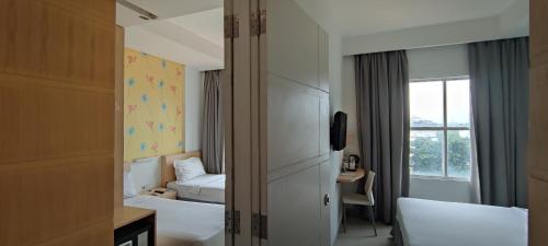 a hotel room with two beds and a window at Liberta Hotel Kemang in Jakarta