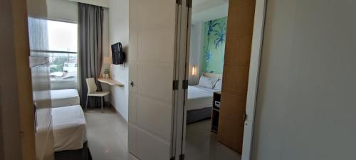 a hotel room with a bed and a sliding door at Liberta Hotel Kemang in Jakarta
