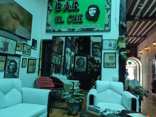 a living room with couches and posters on the wall at Hotel el Che No apto para corruptos in Azogues