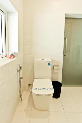 a white toilet in a bathroom with a window at Golden Star Beach Hotel in Negombo