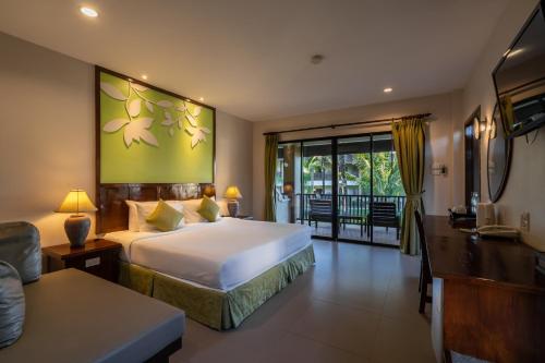 a hotel room with a bed and a living room at The Leaf Oceanside by Katathani - SHA Extra Plus in Khao Lak