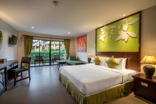 a hotel room with a large bed and a desk at The Leaf Oceanside by Katathani - SHA Extra Plus in Khao Lak