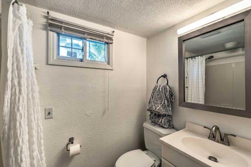a bathroom with a toilet and a sink and a window at Tropical Port Charlotte Cottage - Walk to Bay! in Port Charlotte
