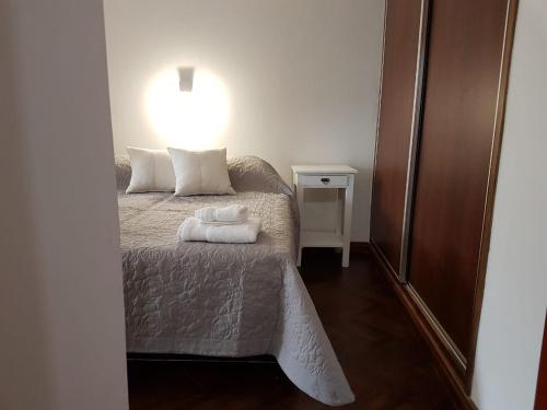 a bedroom with a bed with two towels on it at Balcón de los Campanarios in Salta