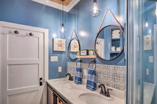 baño con paredes azules, lavabo y 2 espejos en Central Cottage with Grill, 1 Mi to Cajun Field en Lafayette