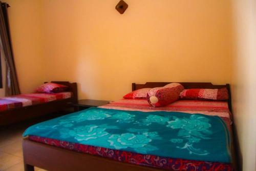 a bedroom with a bed with a blue comforter at Nguntara Gati in Sleman