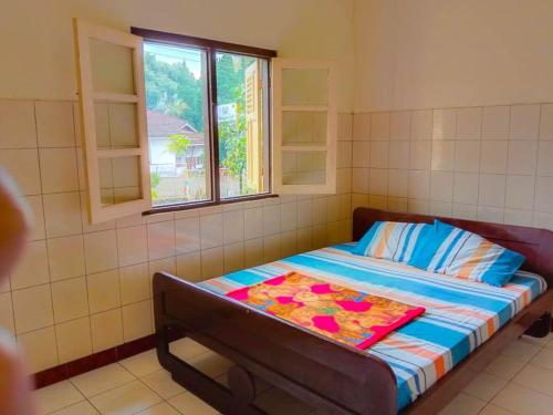 a bed in a room with a window at Nguntara Gati in Sleman