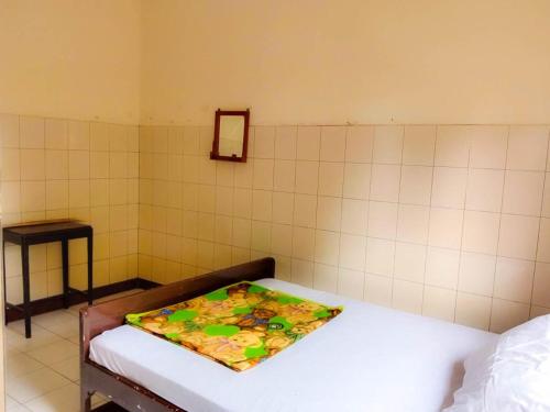 a room with a bed with a blanket on it at Nguntara Gati in Sleman
