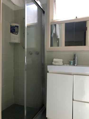 y baño con ducha y lavamanos. en Evancourt Motel Malvern East, en Melbourne