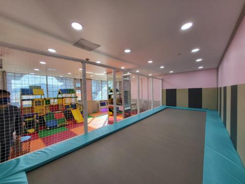 a room with a net with a play area at Home Fourest Resort Geoje in Geoje 