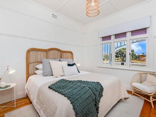 ein weißes Schlafzimmer mit einem großen Bett und einem Fenster in der Unterkunft The Anchor House in Port Fairy