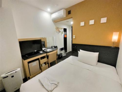 een hotelkamer met een bed en een televisie bij Sotetsu Fresa Inn Nihombashi-Ningyocho in Tokyo