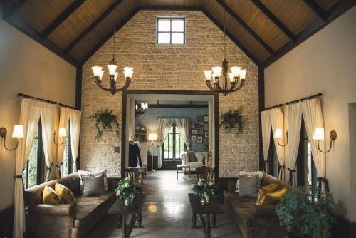 a living room with couches and a brick wall at Thames Valley Khao Yai - SHA Plus in Mu Si