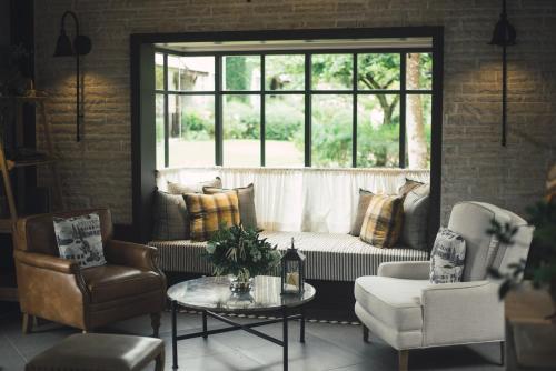 a living room with a couch and two chairs and a table at Thames Valley Khao Yai - SHA Plus in Mu Si