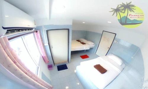 Habitación pequeña con cama y espejo. en Phangan Mantra Inn, en Haad Rin