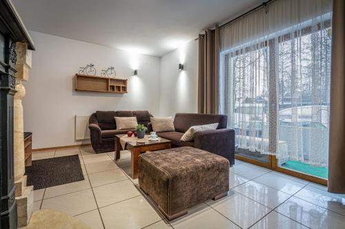 ein Wohnzimmer mit zwei Sofas und einem Tisch in der Unterkunft Willa Cicha Woda III in Zakopane