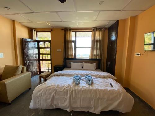 1 dormitorio con 1 cama con 2 toallas en Redeem Cafe & Homestay, en McLeod Ganj