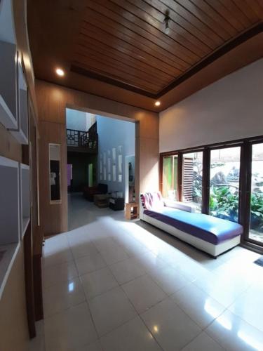 a bedroom with a bed and a large window at Mocca Guest House in Banyuwangi