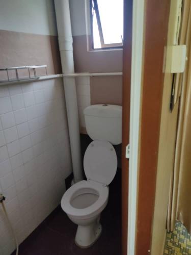 a small bathroom with a toilet and a window at Marina Hotel Kemaman in Kemaman