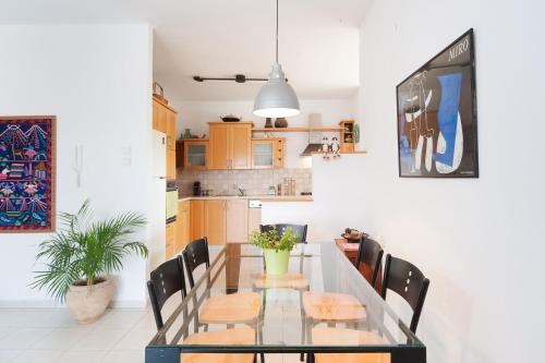 a dining room with a glass table and chairs at Kfar Saba View Apartment in Kefar Sava