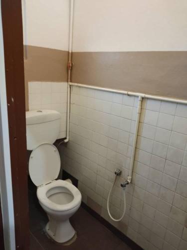 a bathroom with a white toilet in a stall at Marina Hotel Kemaman in Kemaman