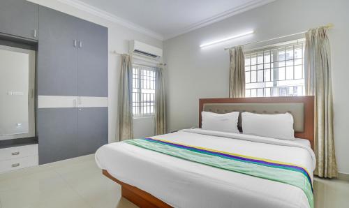 a bedroom with a large bed with a colorful blanket at Treebo Rithikha Inn Elite Chennai Trade Centre in Chennai
