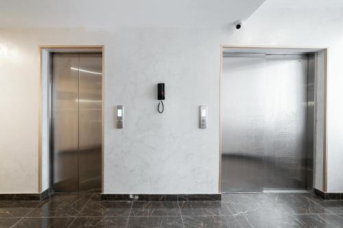 two elevator doors in a room with a wall at Orient Hotel Bishkek in Bishkek