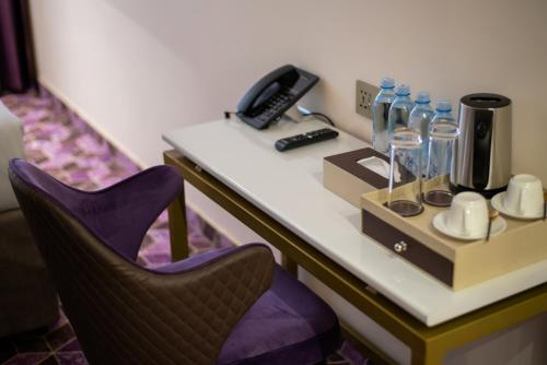 a desk in a hotel room with a phone and a chair at Orient Hotel Bishkek in Bishkek