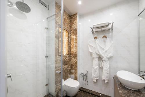 a bathroom with a shower and a toilet and a sink at Orient Hotel Bishkek in Bishkek