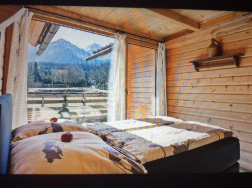 1 dormitorio con 1 cama en una habitación con ventana en Fuxhouse mit Carport -Faakersee -Aichwaldsee gratis Seezugang, en Ledenitzen