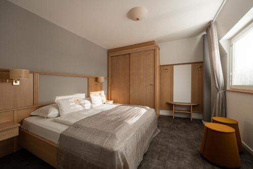 a bedroom with a large bed and a window at Apartmenthotel Ritterhof Suites & Breakfast in Schenna