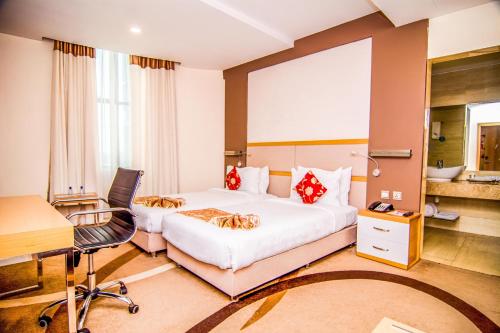a hotel room with two beds and a desk and a desk at PrideInn Azure Hotel Nairobi Westlands in Nairobi