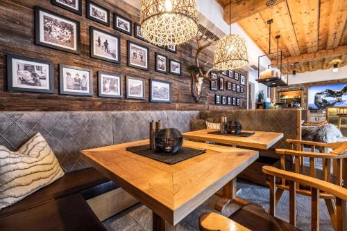 a restaurant with wooden tables and pictures on the wall at Hotel Schützenhof in Flachau