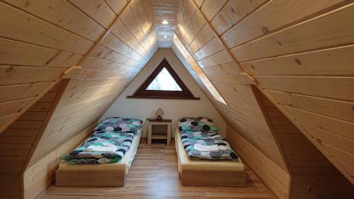 a attic room with two beds and a window at Jurgowski Domek in Jurgów