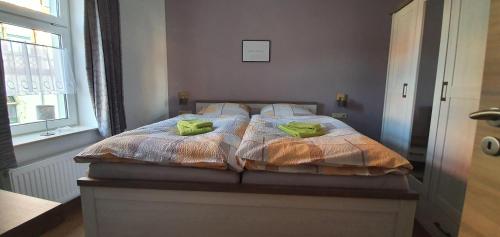 a bedroom with a bed with green towels on it at Ferienwohnung-Am-Markt in Harzgerode