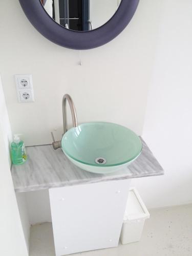 a bathroom sink with a green glass bowl on a counter at Business Hostel Wiesbaden ONE in Wiesbaden