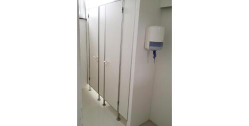 a row of white wardrobes in a room at Business Hostel Wiesbaden ONE in Wiesbaden