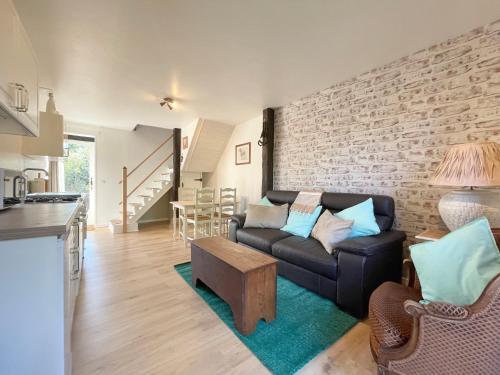 un salon avec un canapé et un mur de briques dans l'établissement Maison De L'Etang, à Essey