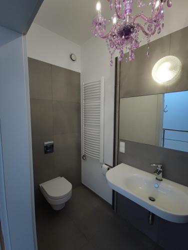 a bathroom with a sink and a toilet and a chandelier at Villa Art deco in Dębica