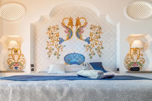 a bedroom with a large bed with a blue blanket at Hotel La Bitta - Bovis Hotels in Àrbatax