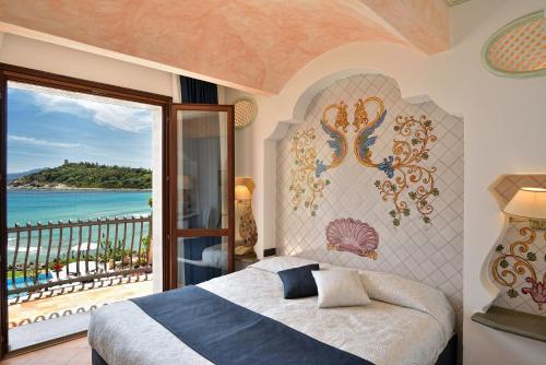 a bedroom with a bed and a view of the ocean at Hotel La Bitta - Bovis Hotels in Àrbatax