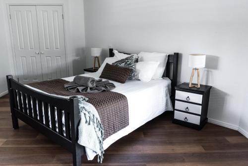 a bedroom with a black and white bed and a night stand at The Bearded Dragon Boutique Hotel in Mount Tamborine