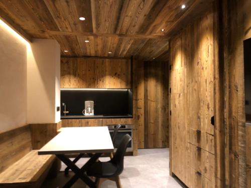 a room with a table and a tv and wooden walls at Appartement 4 à 5 personnes in Val dʼIsère