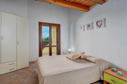 ein weißes Schlafzimmer mit einem Bett und einem Fenster in der Unterkunft Trilo Orizzonti 31 in Golfo Aranci