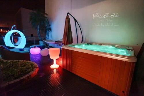 a jacuzzi tub in a living room with a table and an umbrella at Villa Le Ballon Bleu in Wujie