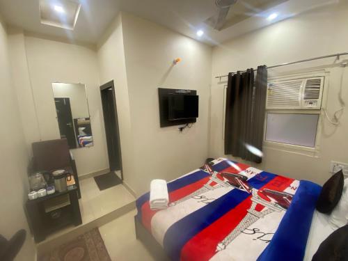 a bedroom with a bed and a tv in a room at Hotel Gopal in Haridwār