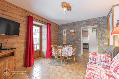 a living room with a table and a tv at 153 Rue des Rochers in Lanslevillard